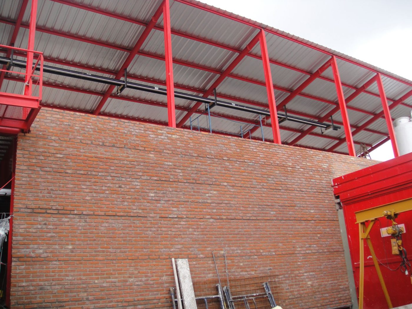 Estructura metálica y muro de mampostería vista en obra industrial